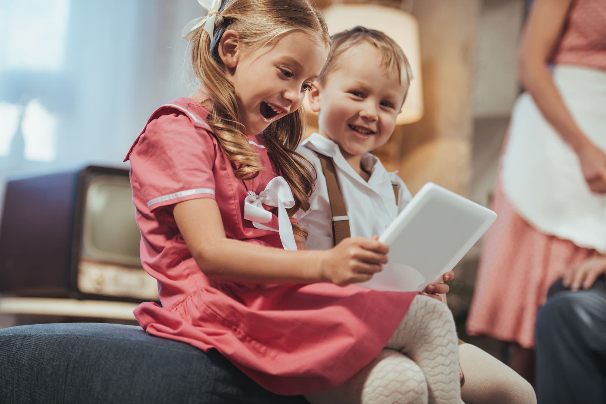 Petite Mauve: dos niños divirtiéndose mirando una serie en una tableta.